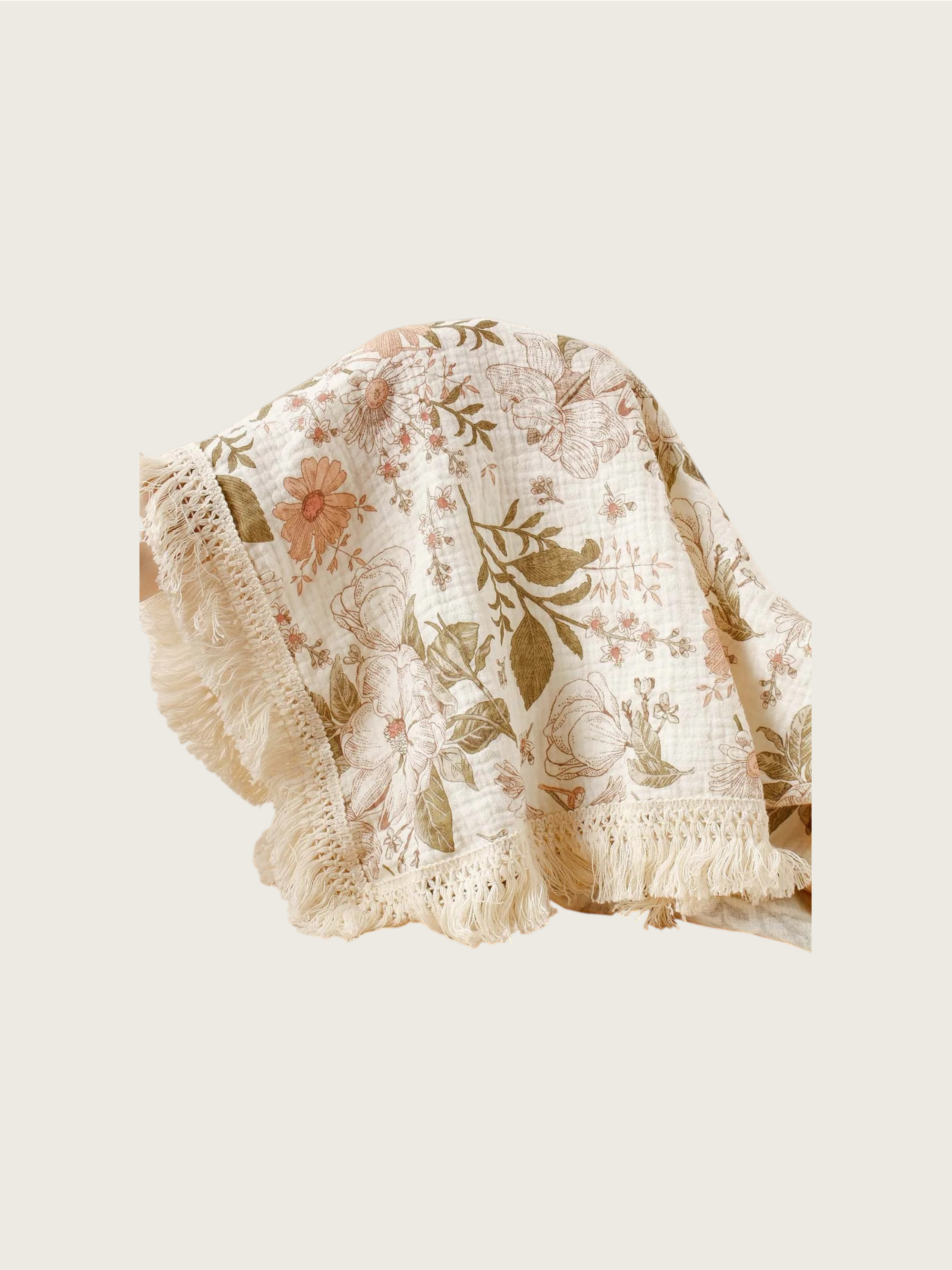 Floral patterned blanket with tassle trim on a light background