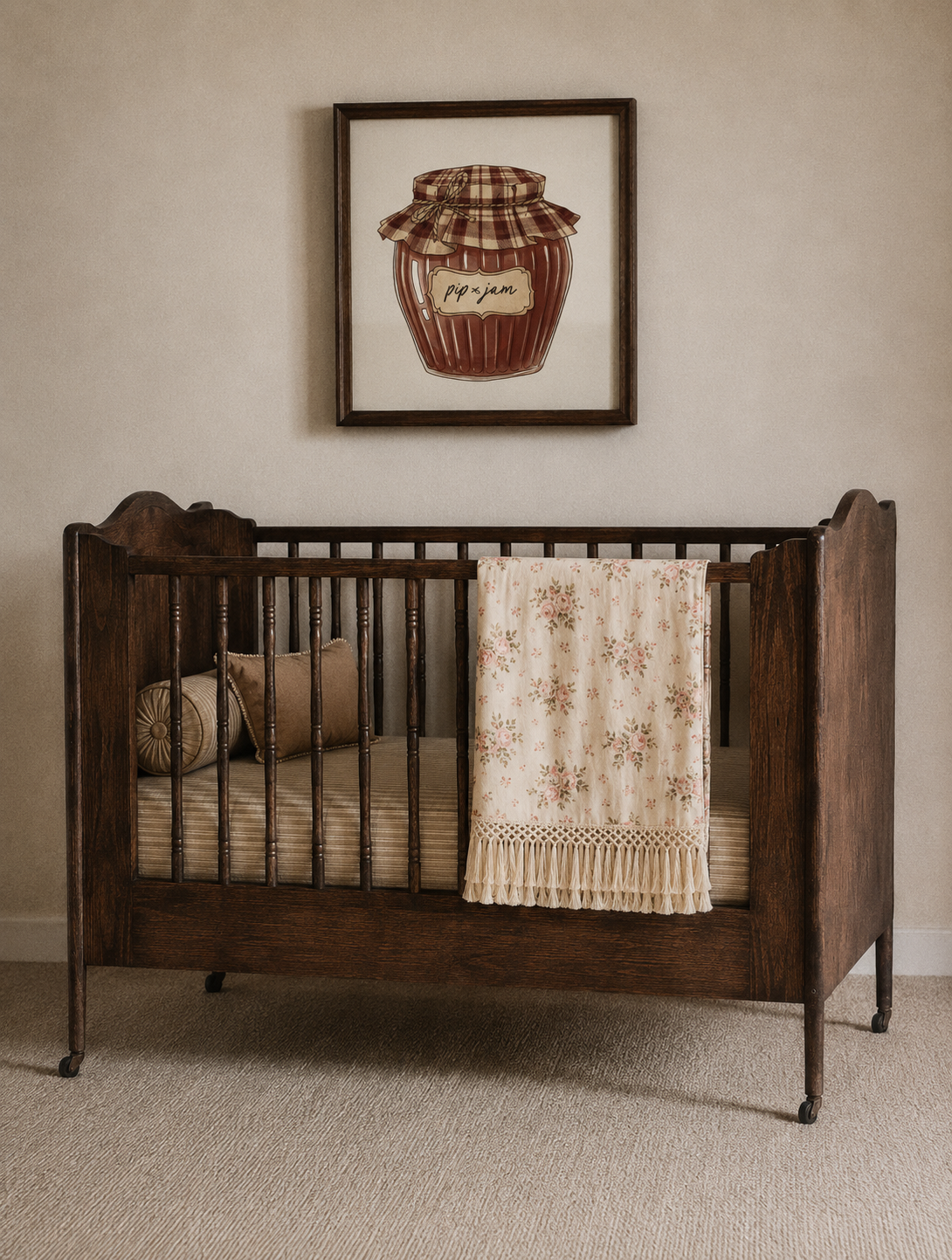 Wooden crib with bedding and a framed picture on the wall in a room with pink floral pattern cotton blanket | Pip & Jam